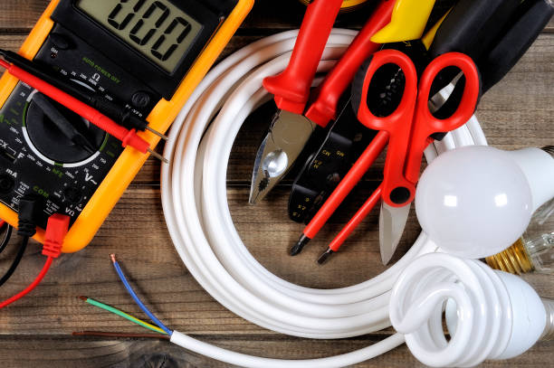 Tester, work tools and electrical equipment on an antique wooden desk.