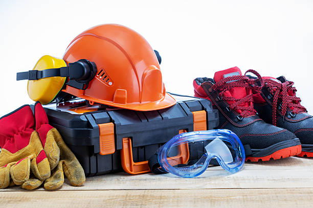 Safety equipment and toolbox on wooden workbench.